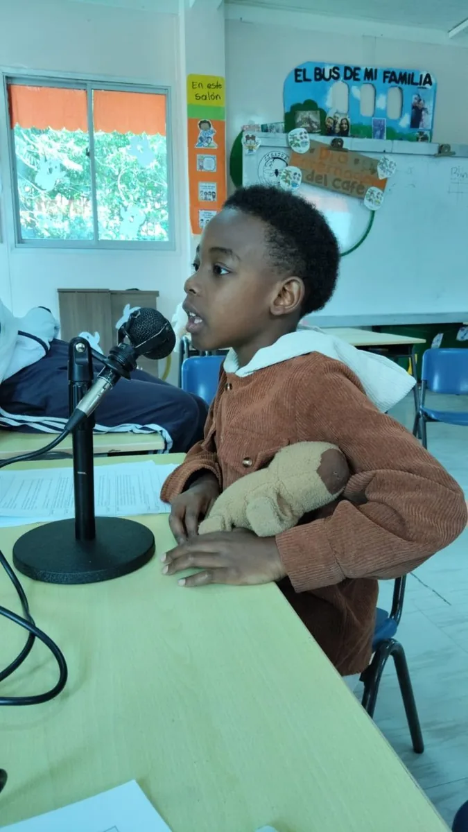 Un niño frente al micrófono durante un taller de Talento Semilla