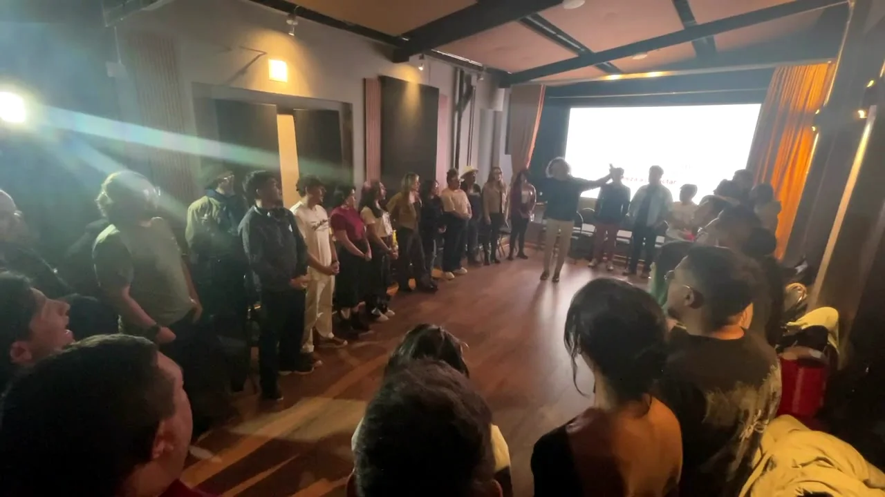Dinámica en círculo de Daniel Gomez: los asistentes de pie frente a la pantalla